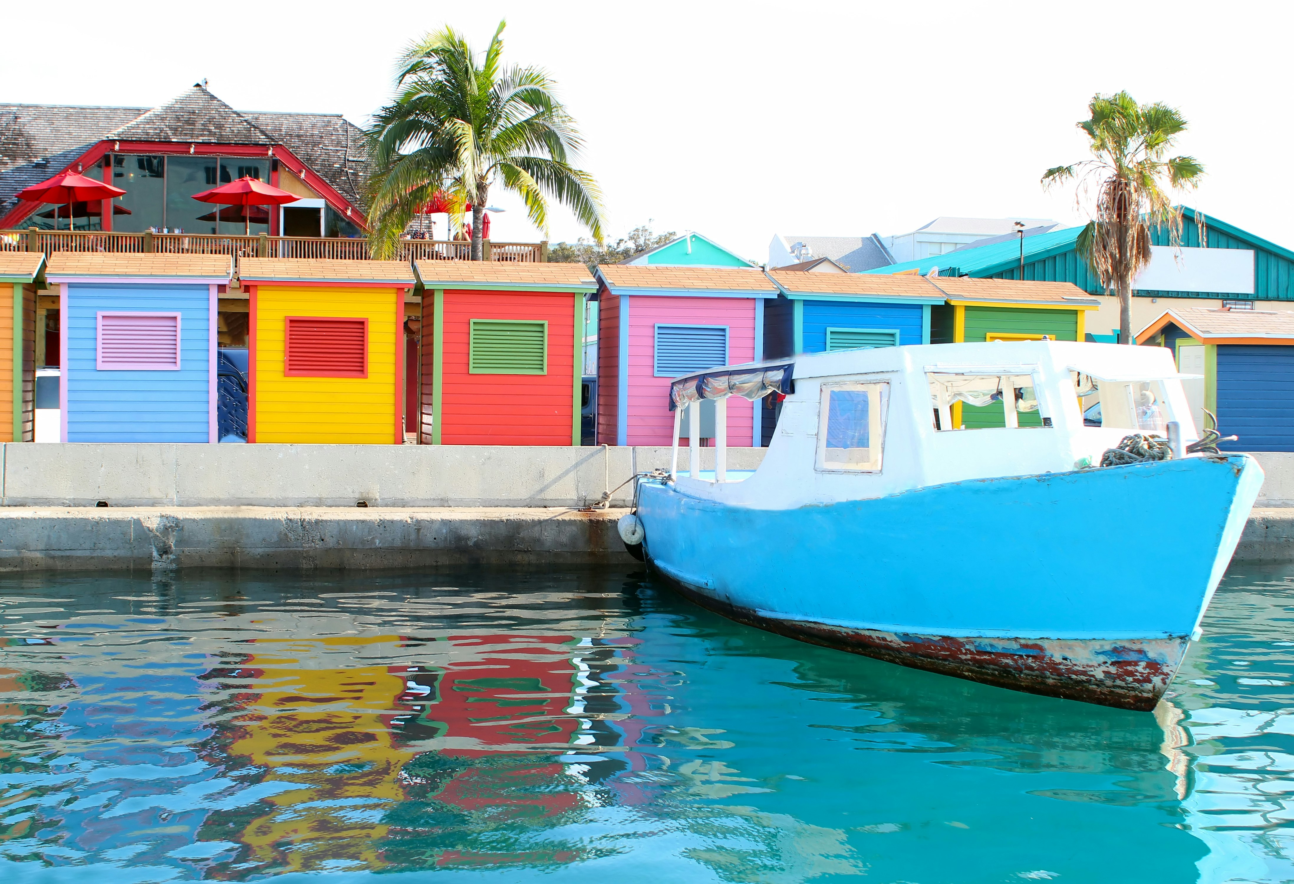 A colorful image of the waterfront area in downtown Nassau showing a water taxi and several huts